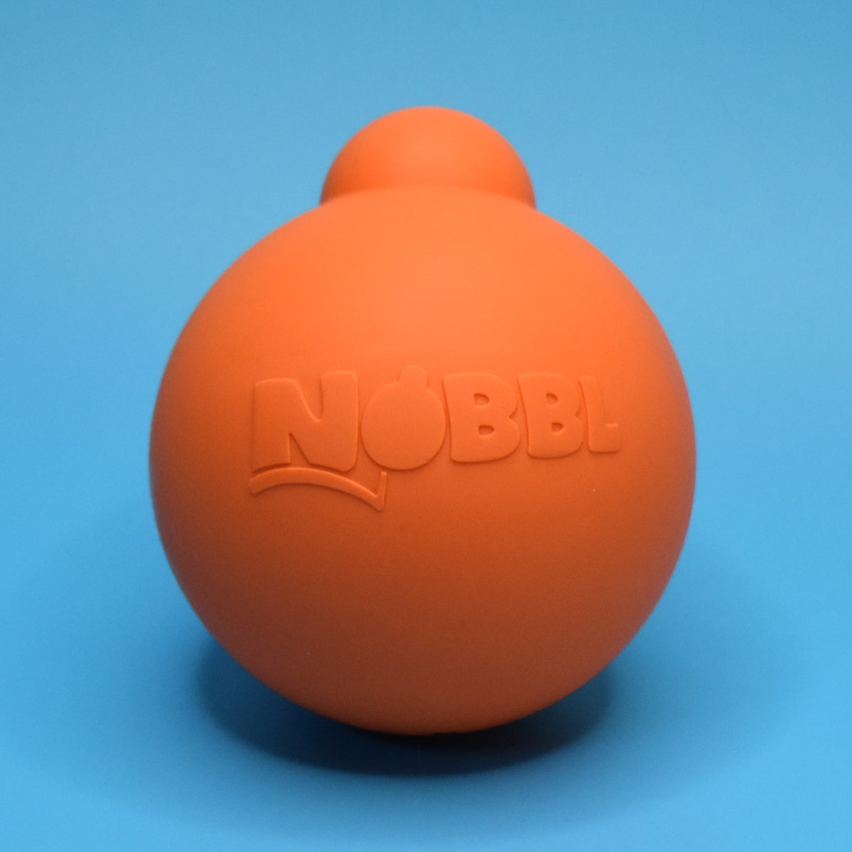 Orange Nobbl toy on a sky blue background.